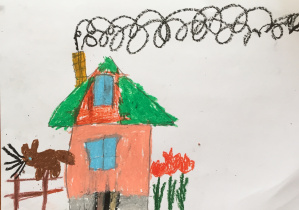 Praca plastyczna Jakuba. Przedstawia domek, z jego komina leci dym, z lewej strony jest płot, na którym siedzi brązowy kot, z prawej strony domu rosną czerwone tulipany.